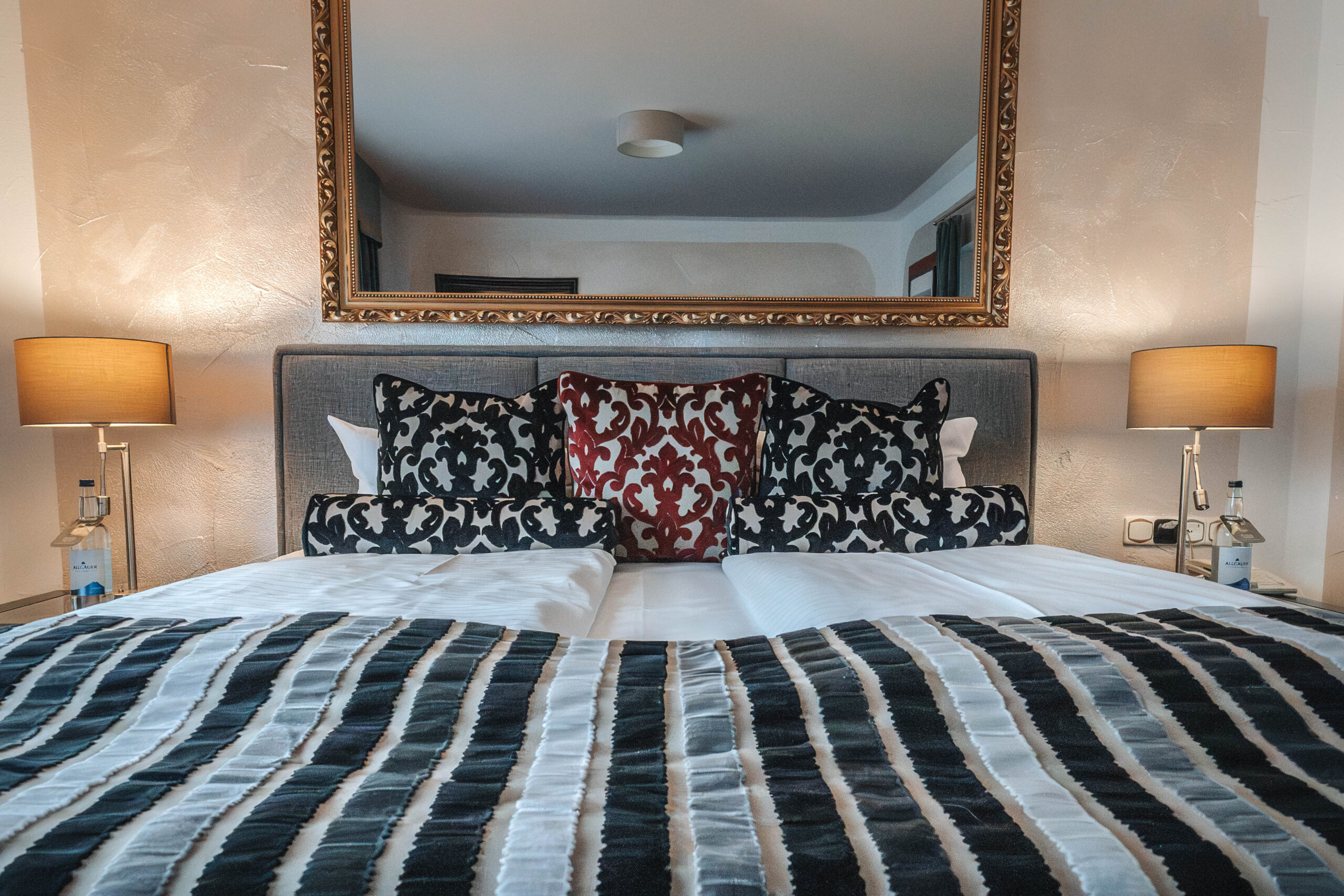 Stilvolles Hotelzimmer mit geschmackvollen Kissen und Bettdecke, ideal für einen erholsamen Familienurlaub im Hotel.