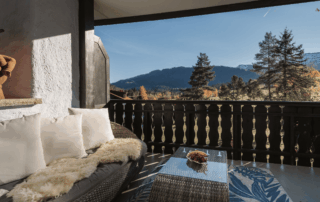 Gemütliche Sitzecke auf dem Balkon des Hotel Alpenglück, mit Blick auf die Berge und die umliegende Natur im Familienurlaub.