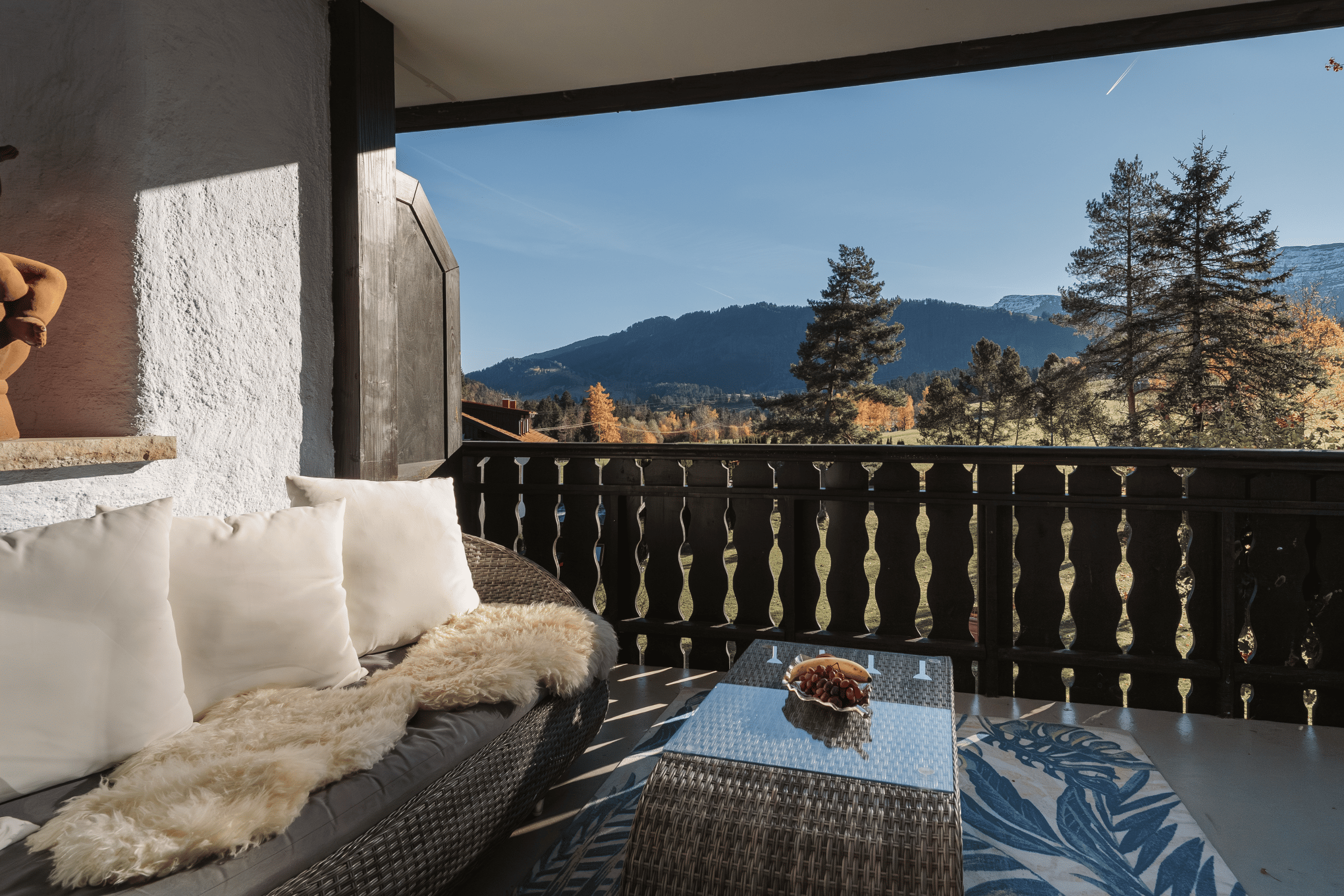 Gemütliche Sitzecke auf dem Balkon des Hotel Alpenglück, mit Blick auf die Berge und die umliegende Natur im Familienurlaub.